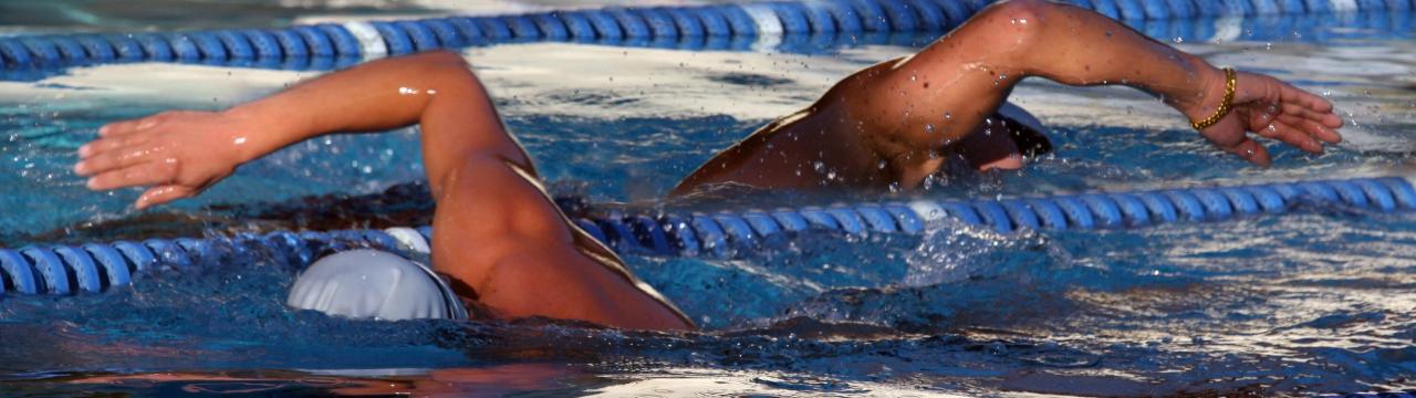 2 Schwimmer*innen im Schimmbecken