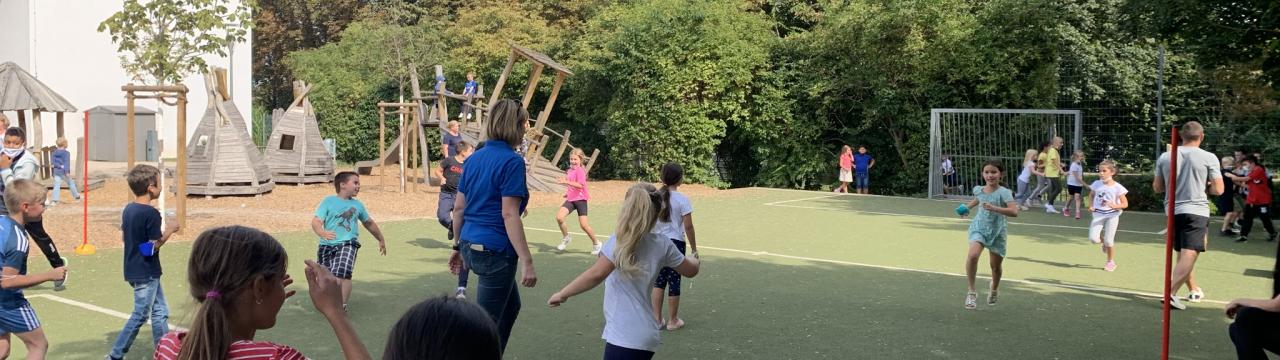 Grundschulkinder spielen auf Sportplatz