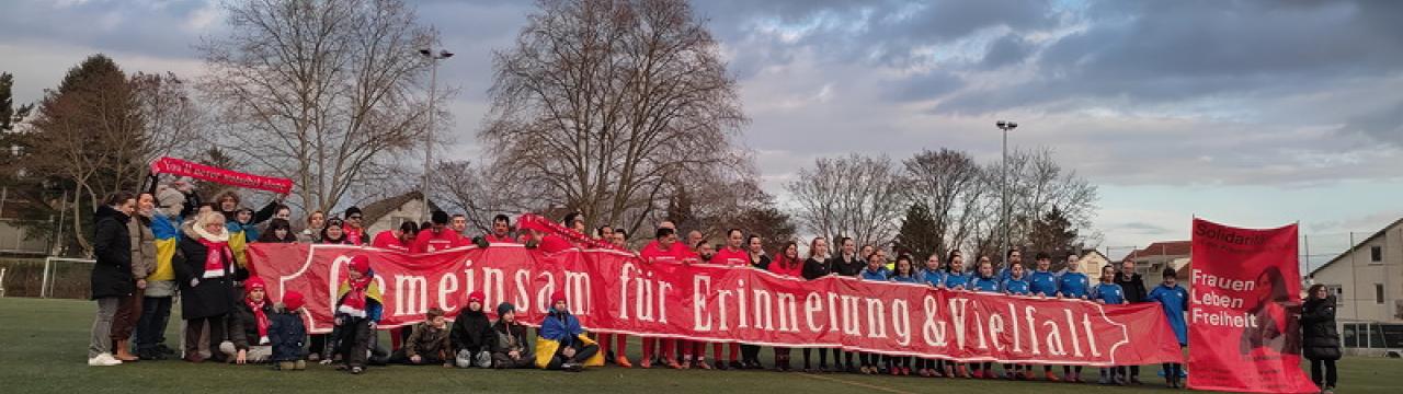 Fc Ente Bagdad erinnert an die NS-Verbrechen mit einem Banner auf dem Fußballplatz.