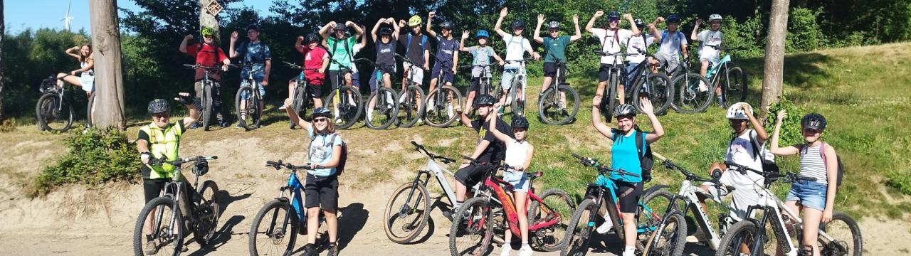 Eine Gruppe von Schüler*innen draußen auf Fahrrädern
