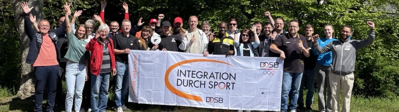 Gruppenfoto mit Banner "Integration durch Sport.