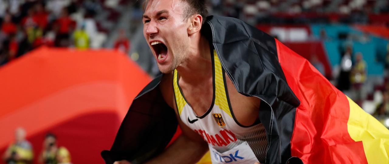 Niklas Kaul mit Deutschlandfahne nach seinem WM-Sieg 2019
