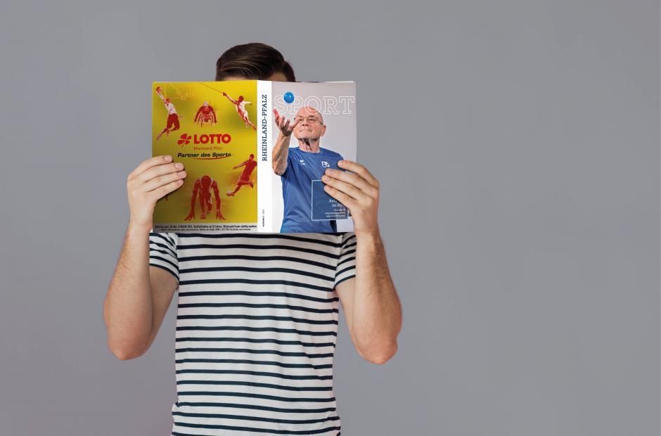 Person, die Magazin vor dem Gesicht hält und liest