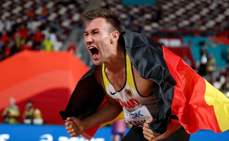 Niklas Kaul mit Deutschlandfahne nach seinem WM-Sieg 2019