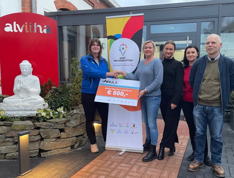 Scheckübergabe mit mehreren Personen