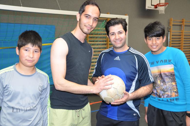 Flüchtlinge in Sporthalle mit Fußball
