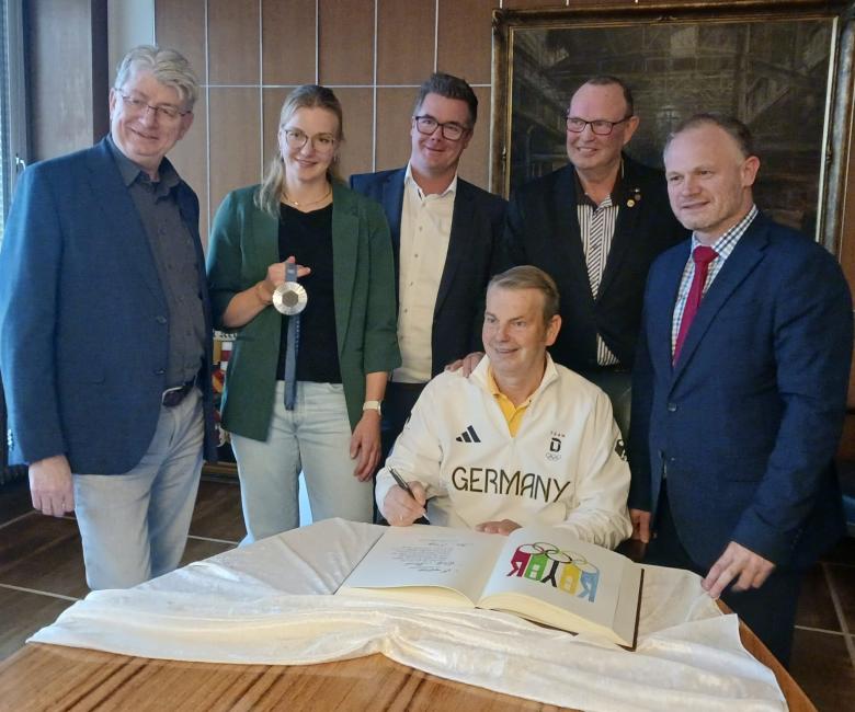 Eintrag ins Goldene Buch mit vielen Umstehenden