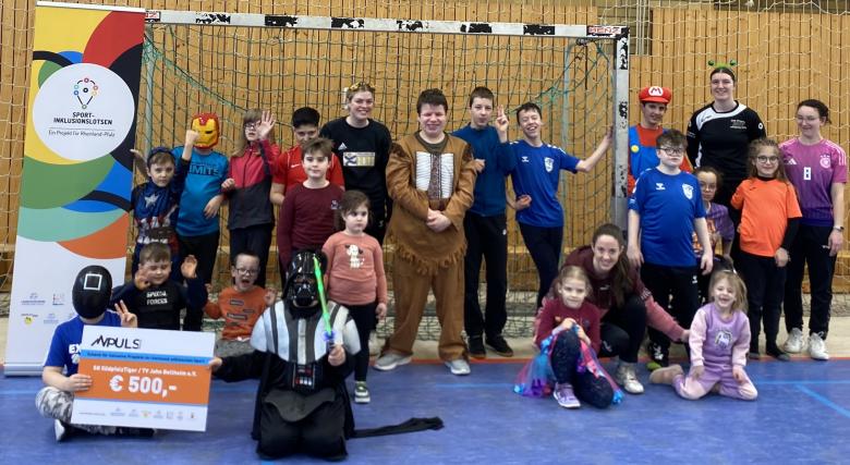 Scheckübergabe mit Kindern im Sporthalle