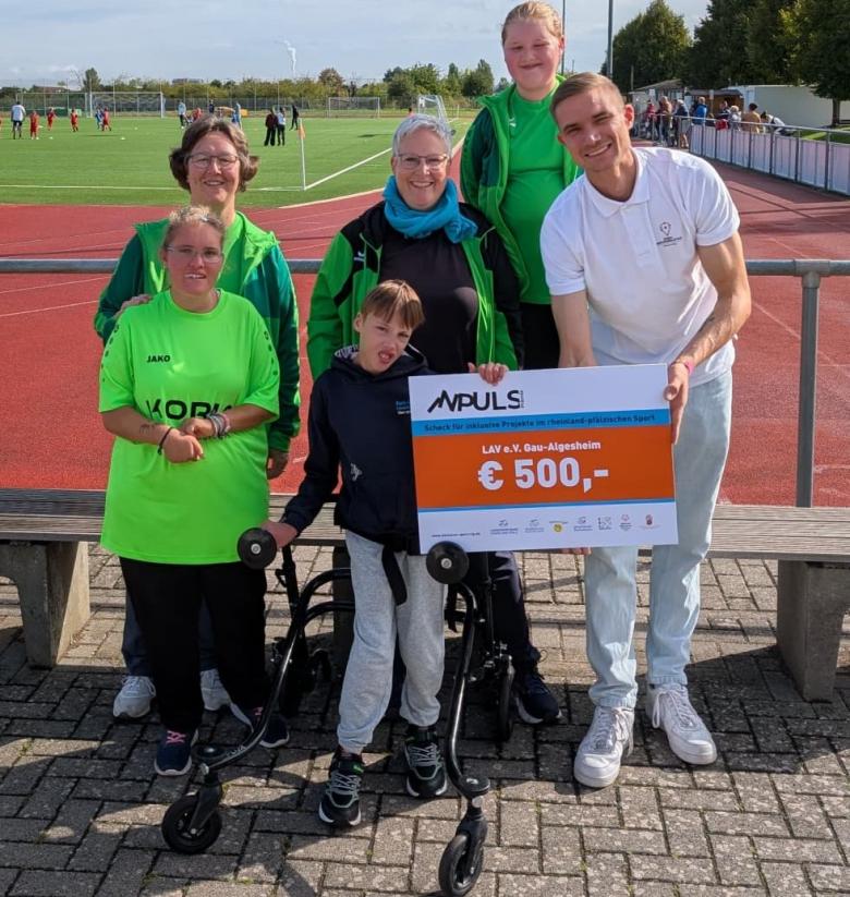 Scheckübergabe auf Sportplatz