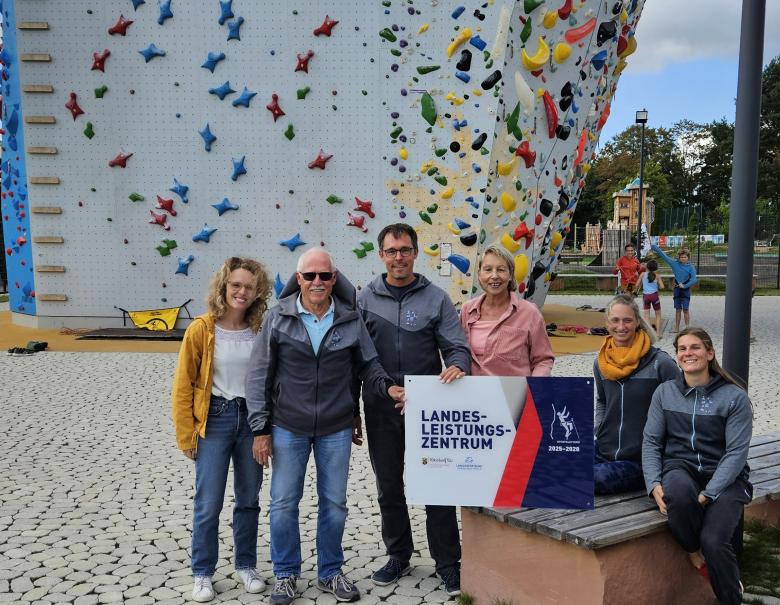 Menschen vor einem Kletterturm