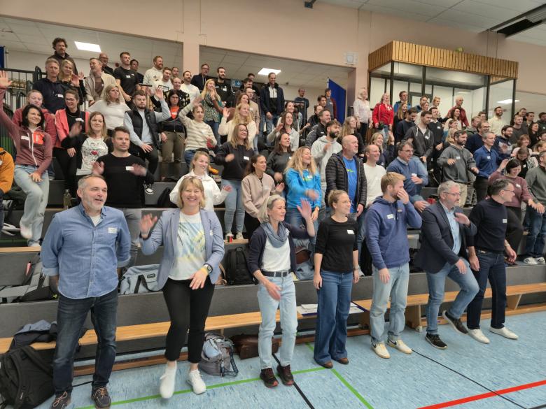 Menschen bewegen sich auf voller Tribüne
