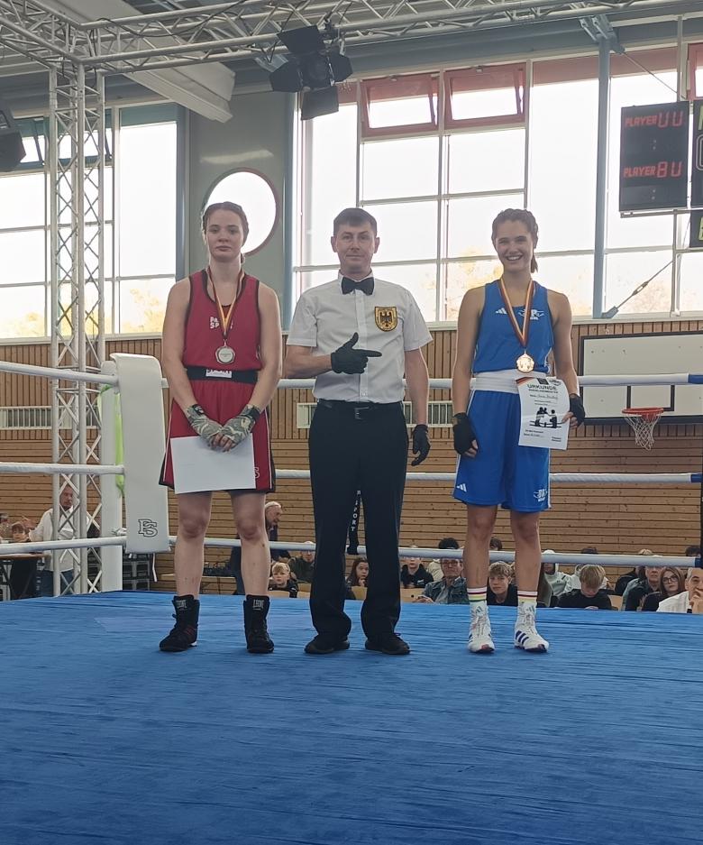 Zwei Boxerinnen und ein Schiedsrichter im Boxring