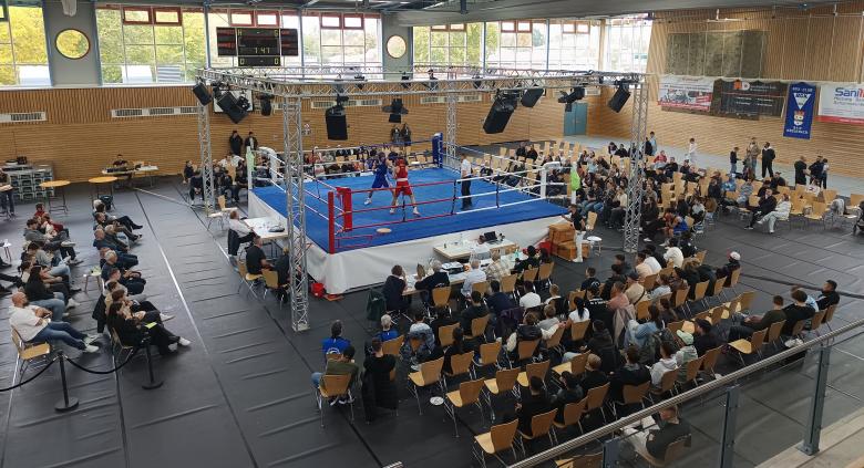 Aufnahmen von oben: Halle mit Boxring und Zuschauern
