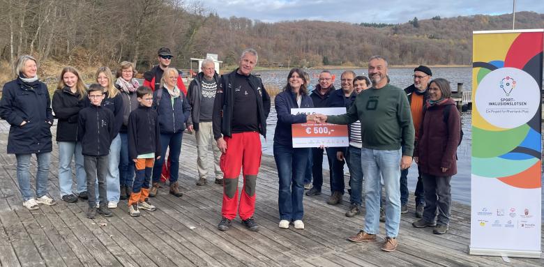 Menschen auf Bootssteg an See