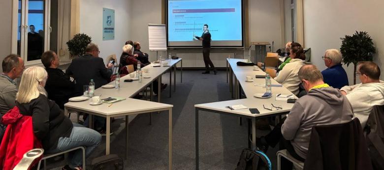 Tagungsteilnehmer an Tischen sitzend