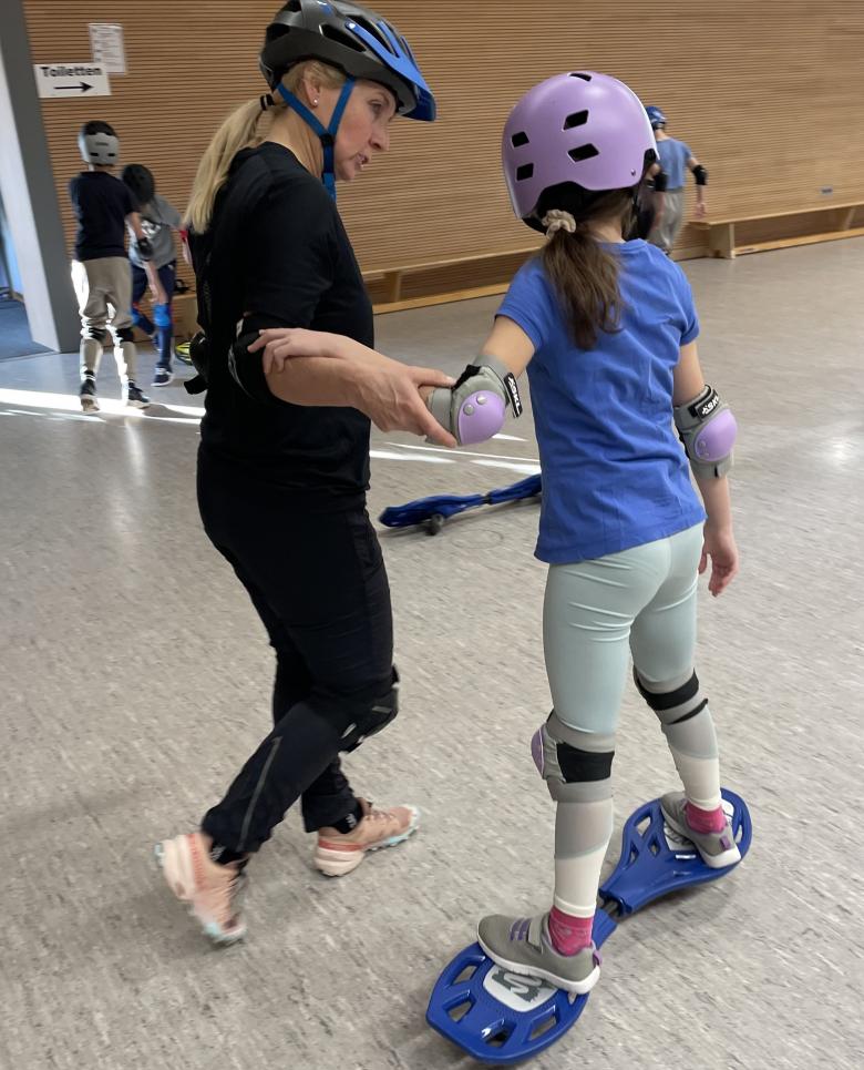 Mädchen auf Waveboard mit Trainerin