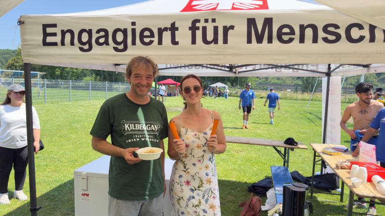 Das Bild zeigt zwei Personen, eine ist mit dem Mittagessen ausgestattet, die andere hält in jeder Hand ein Eis.