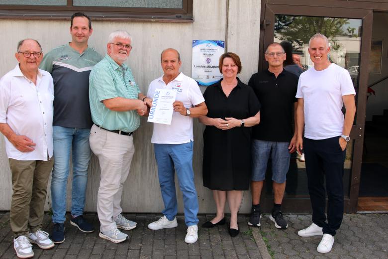 Menschen bei Übergabe von Urkunde