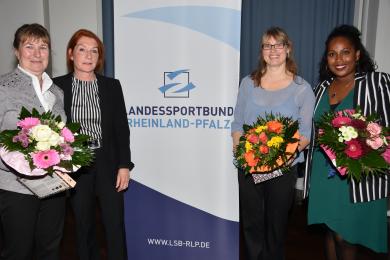 LSB-Vizepräsidentin Claudia Altwasser mit drei geehrten Frauen vor dem Banner des Landessportbundes RLP.