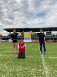 Drei Nachwuchssportler des TuS Ahrweiler 1898 auf dem Fußballplatz halten das LSB-Hygieneplakat
