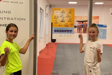 Traningshalle des Sen5 Karate Verein e.V. mit einem LSB-Hygieneplakat und einem Teil des Nachwuchs-Wettkampfteams.  