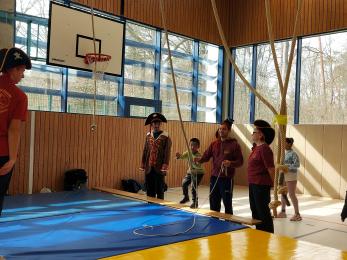 Kinder in der Turnhalle an verschiedenen Stationen