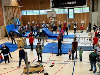 Kinder in der Turnhalle an verschiedenen Stationen