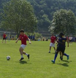Ein Junge im roten Fußballtrikot läuft einem Ball hinterher.