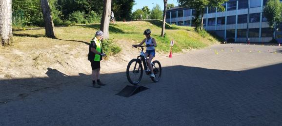 Mädchen auf Fahrrad fährt über kleine Rampe
