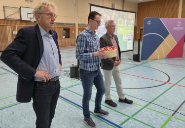 Drei Menschen in Sporthalle