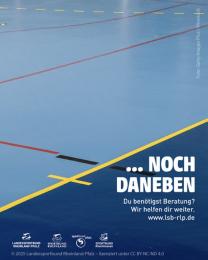 "...noch daneben" auf Foto von blauem Hallenboden