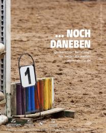 "...noch daneben" auf Foto eines Reitplatzes