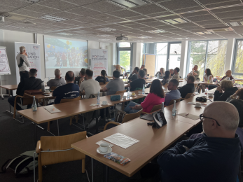 Das Foto zeigt die Teilnehmenden des Netzwerktreffens und Programmreferent Milan Kocian, der Einblicke in die aktuelle Programmarbeit gibt.