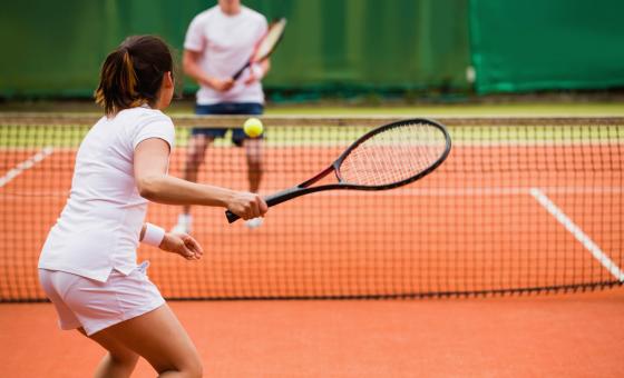 Tennisplatz mit zwei Tennisspielern im Hintergrund