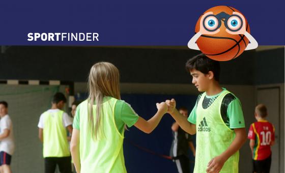 Sportfinder-Aktion in einer Turnhalle. Zwei Kinder klatschen sich beim Sport ab.