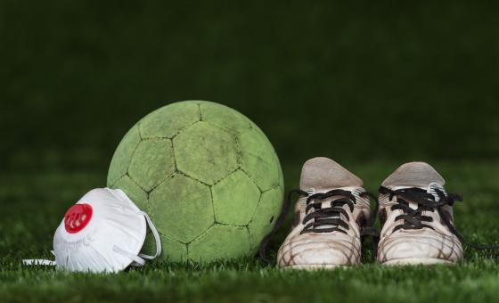 Symbolbild Corona und Sport. Atemschutzmaske mit Fußball