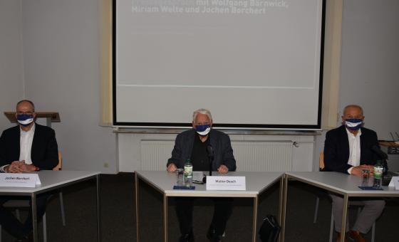 Drei Männer mit Mundschutz