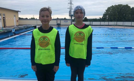Zwei Kinder vor einem Schwimmbecken