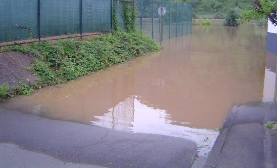 Überflutete Straße und Sportanlage
