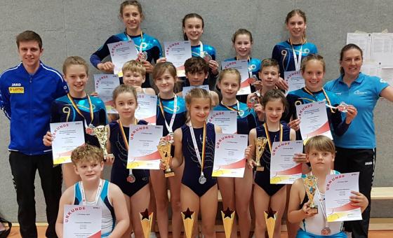 Trampolin-Kinder mit Trainer*innen
