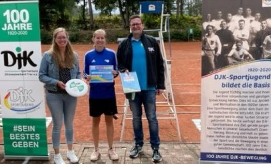 Drei Personen vor Tennisplatz