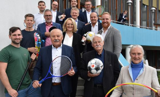 Männer und Frauen mit Sportgeräten in der Hand
