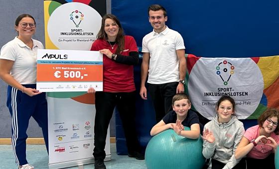 Spendenübergabe mit Sportler*innen in Sporthalle