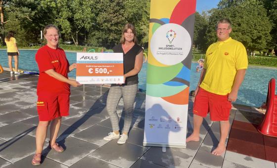 Personen mit Scheck im Freibad