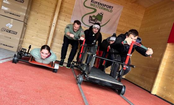 5 Sportler*innen, die den Anschub eines Bobs simulieren