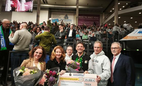 Scheckübergabe in großer Sporthalle