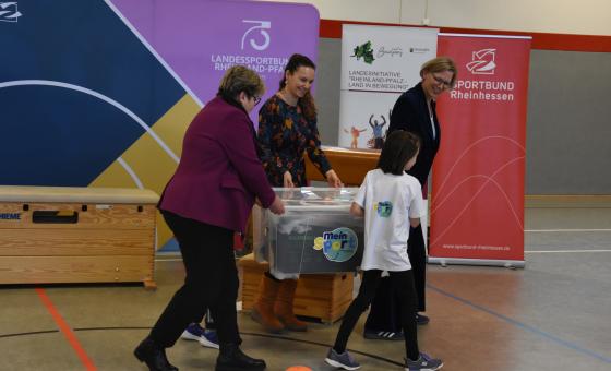 Erwachsene und Kind in Sporthalle