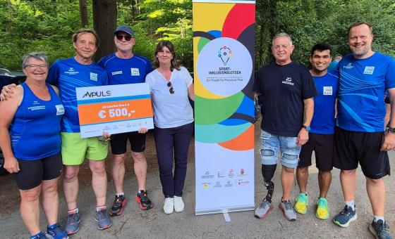 Laufgruppe mit symbolischem Scheck