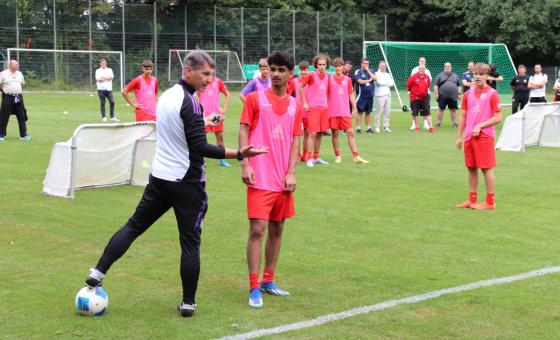Fußballer mit Trainer auf dem Rasen