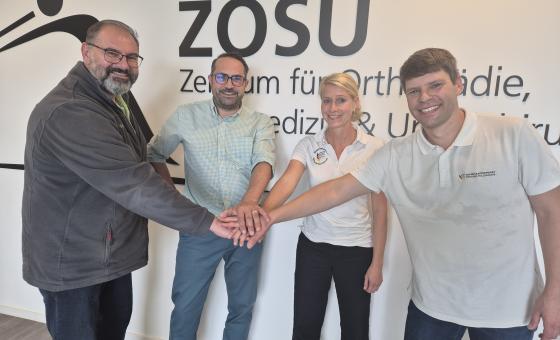 Vier Menschen mit Händen aufeinander